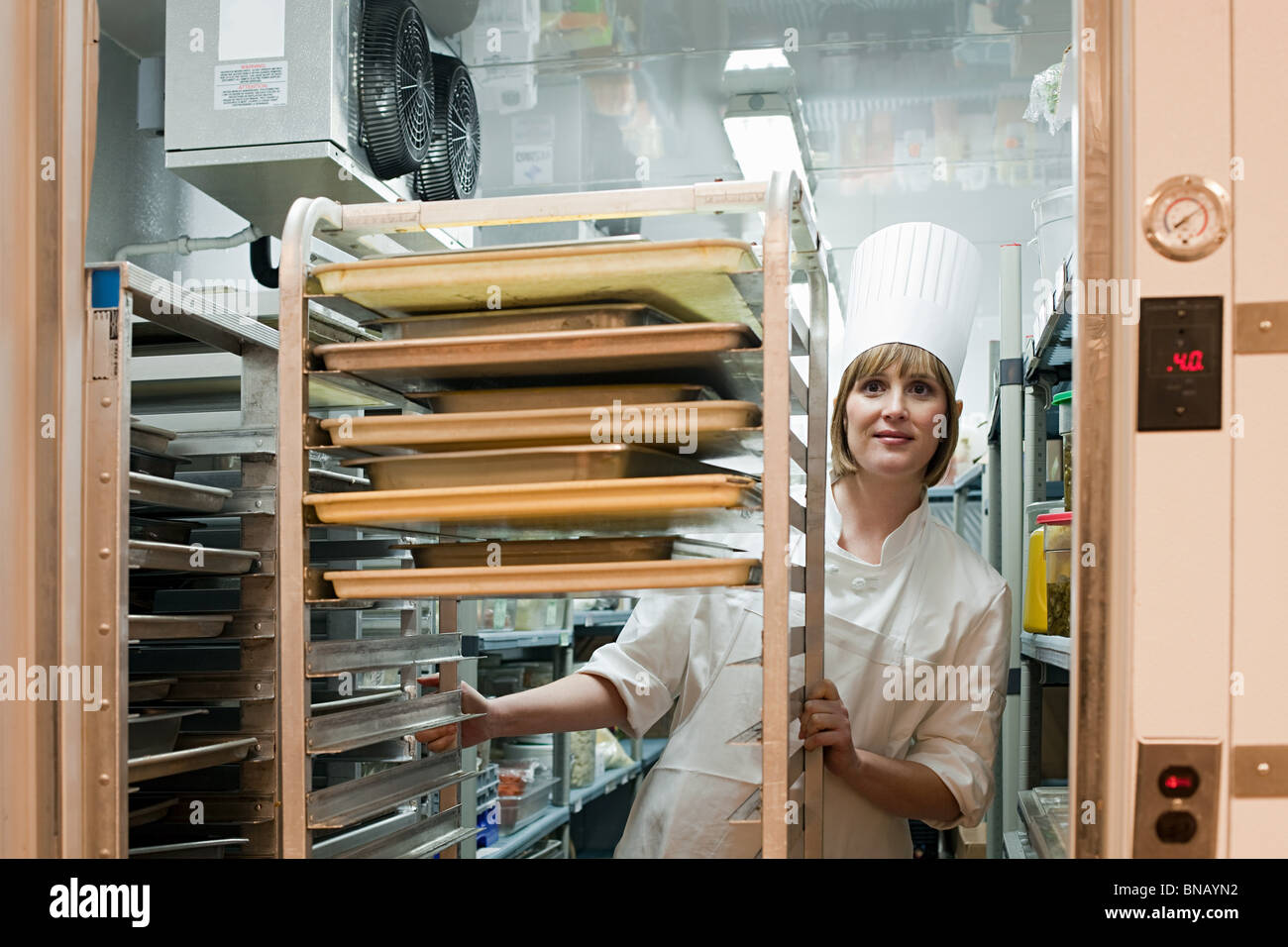 Female chef in walk in freezer in commercial kitchen Stock Photo