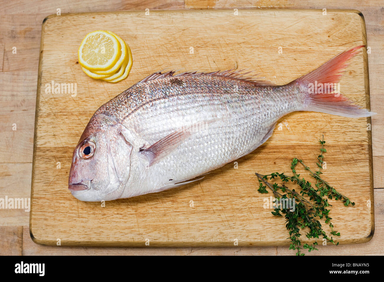 Fish on wooden chopping board Stock Photo - Alamy