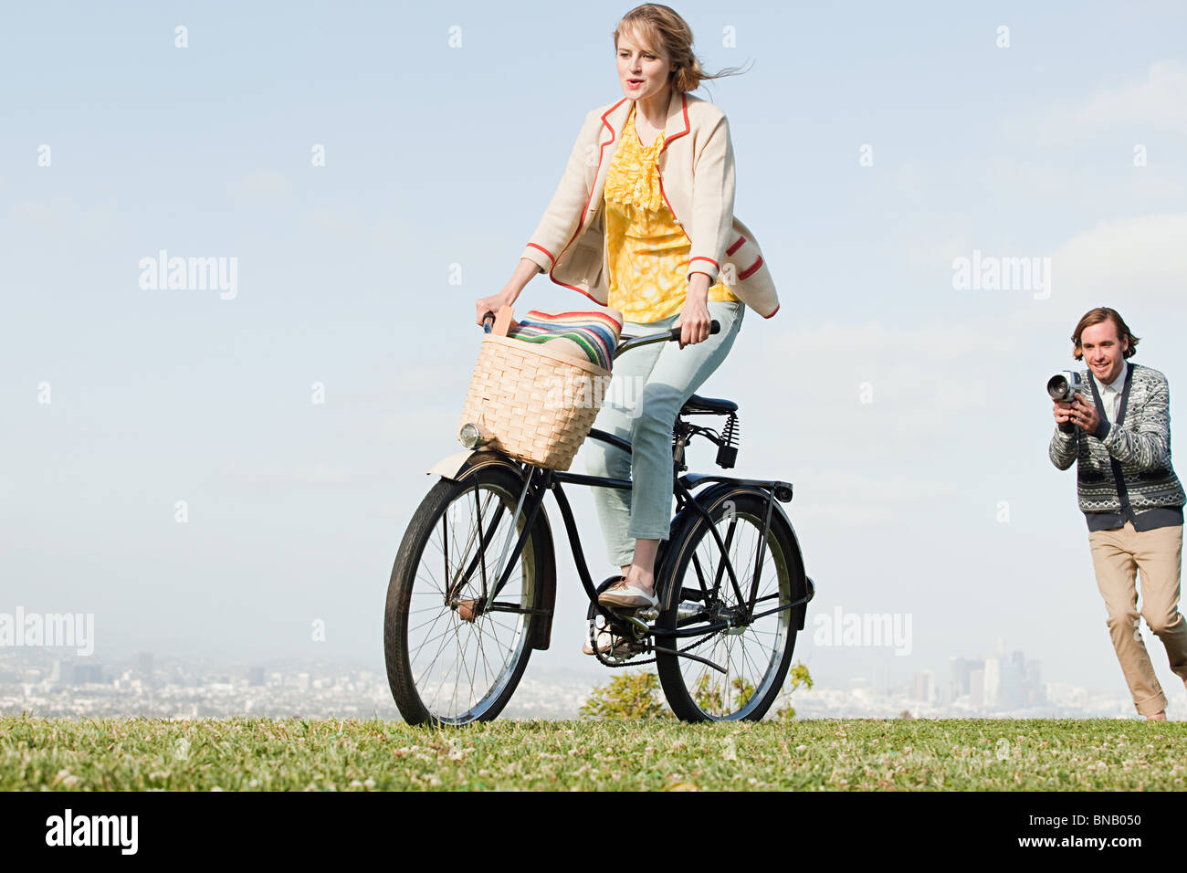 Man filming girlfriend riding a bicycle Stock Photo