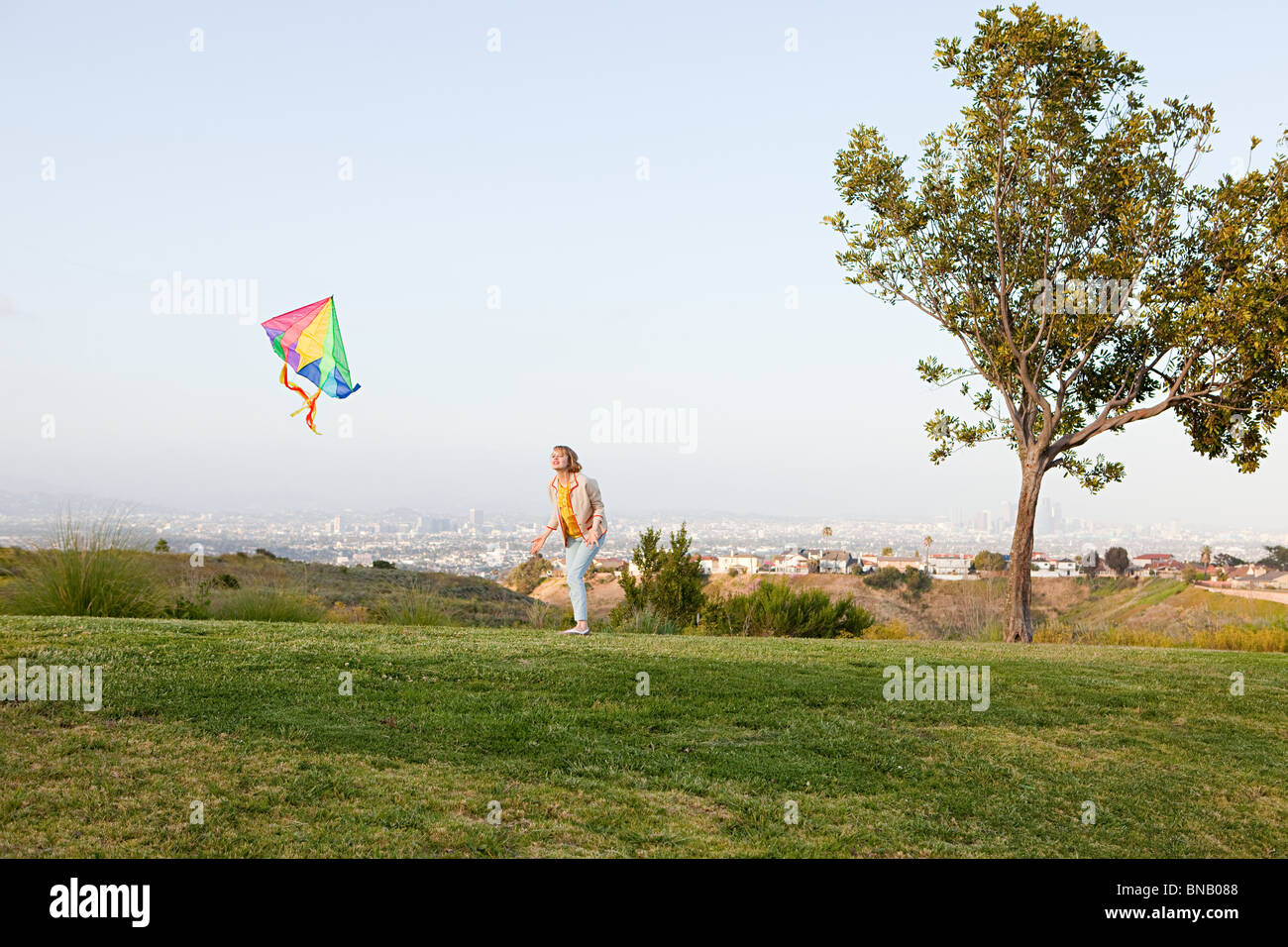 Young woman flying a kite in a field Stock Photo