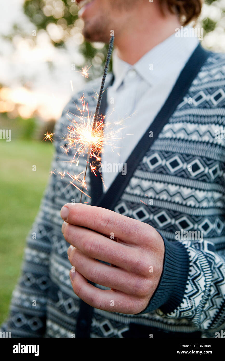 Young man holding a sparkler Stock Photo