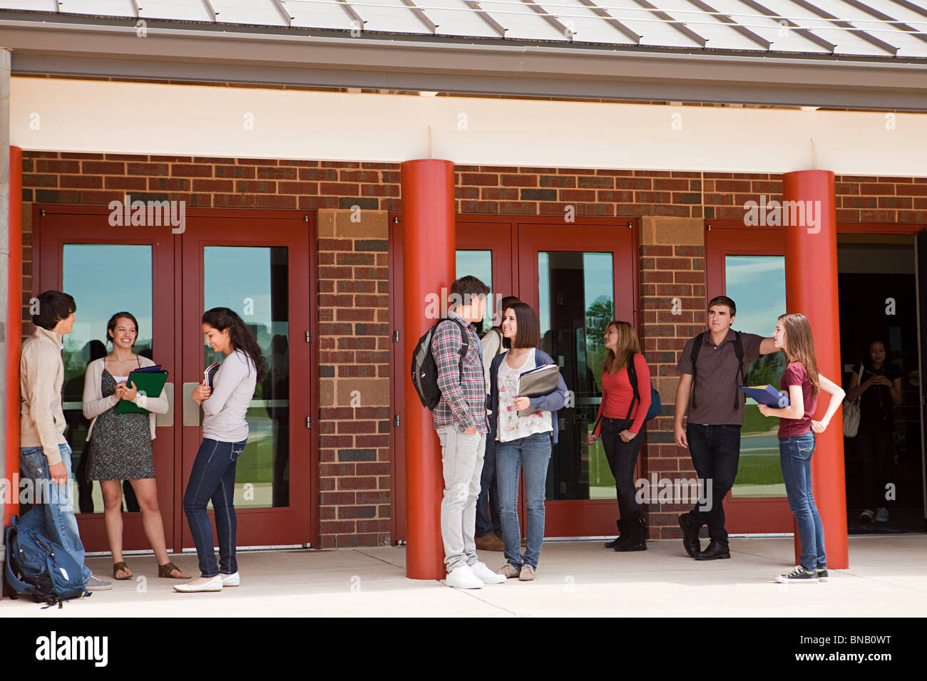 High school students outside school building Stock Photo