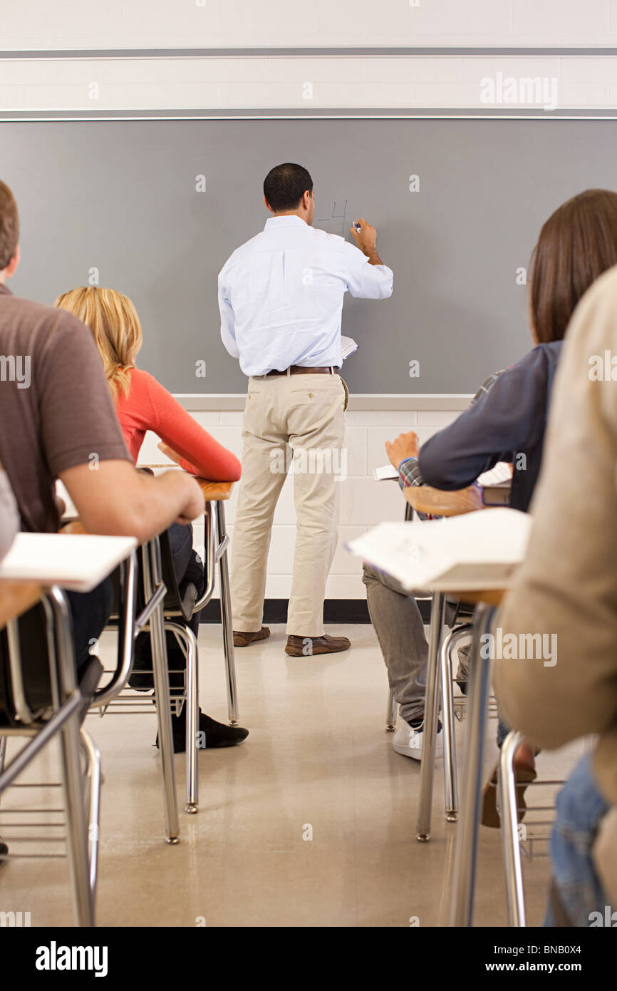 High school teacher using white board in classroom Stock Photo