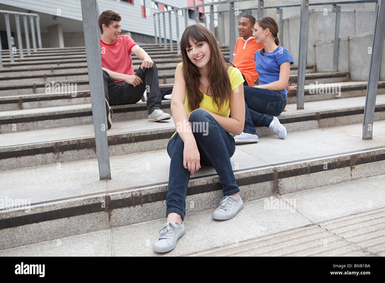 Young people sitting on steps Stock Photo - Alamy