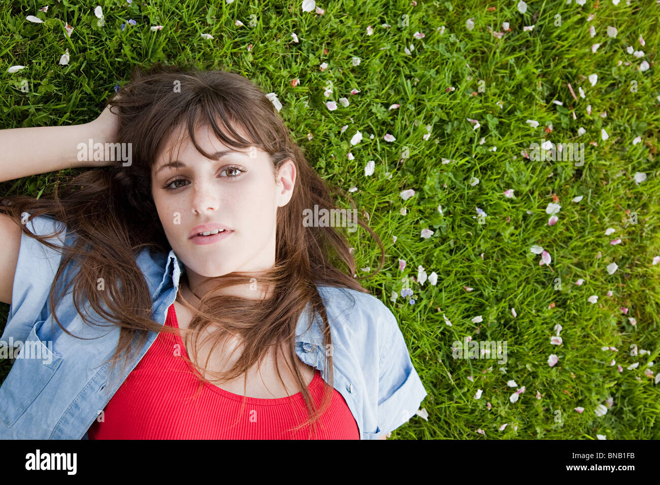 Young woman lying on grass Stock Photo - Alamy