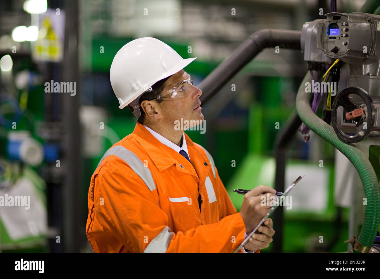Engineer inspecting machinery in factory Stock Photo