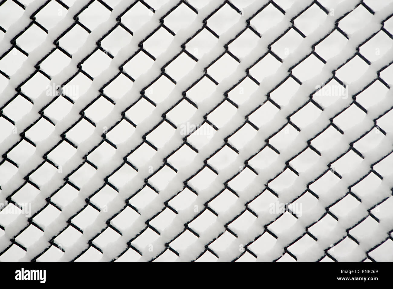 Snow on a chain link fence Stock Photo