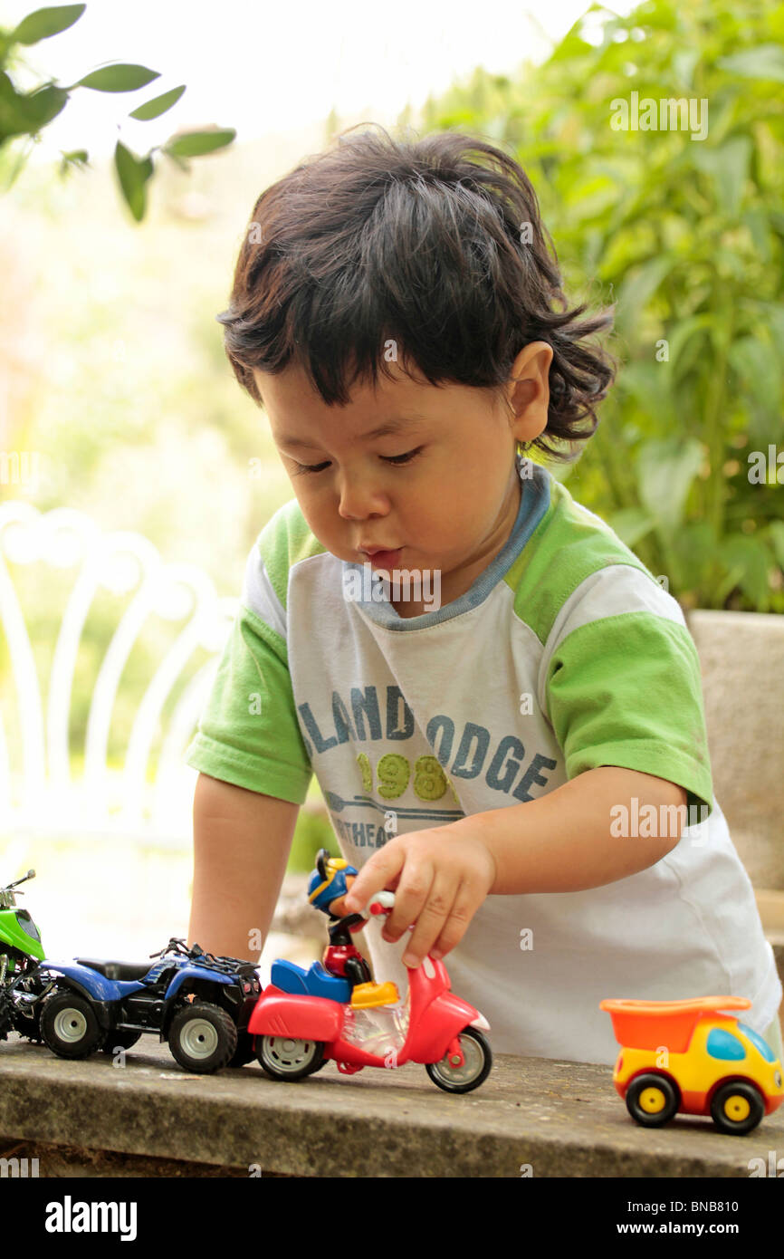Boy playing with toy cars Stock Photo - Alamy