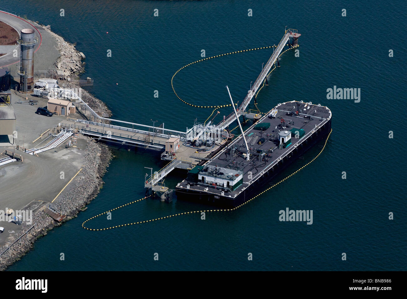 aerial view above oil boom around docked petroleum barge Richmond California Stock Photo