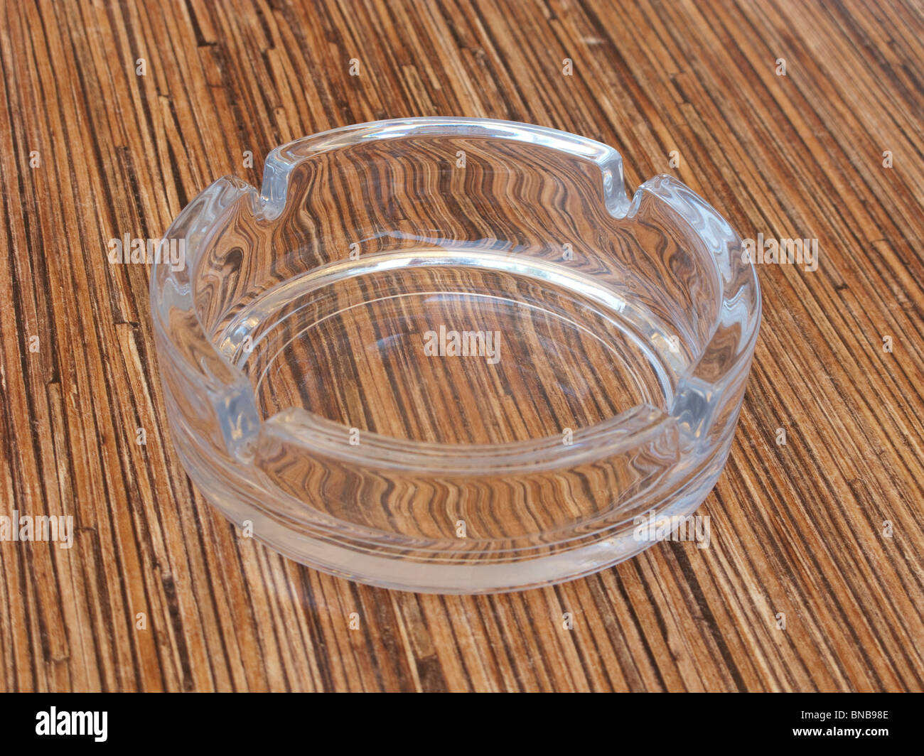Glass ashtray on wooden top . Stock Photo