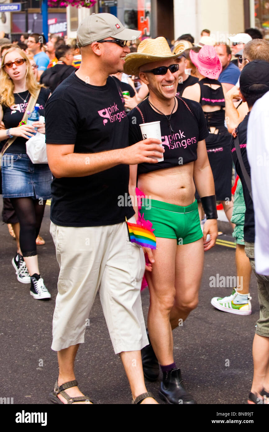 London Gay Pride , young men or boys of the Pink Singers Group dressed in stetson , black tee shirt , sunglasses & green shorts Stock Photo