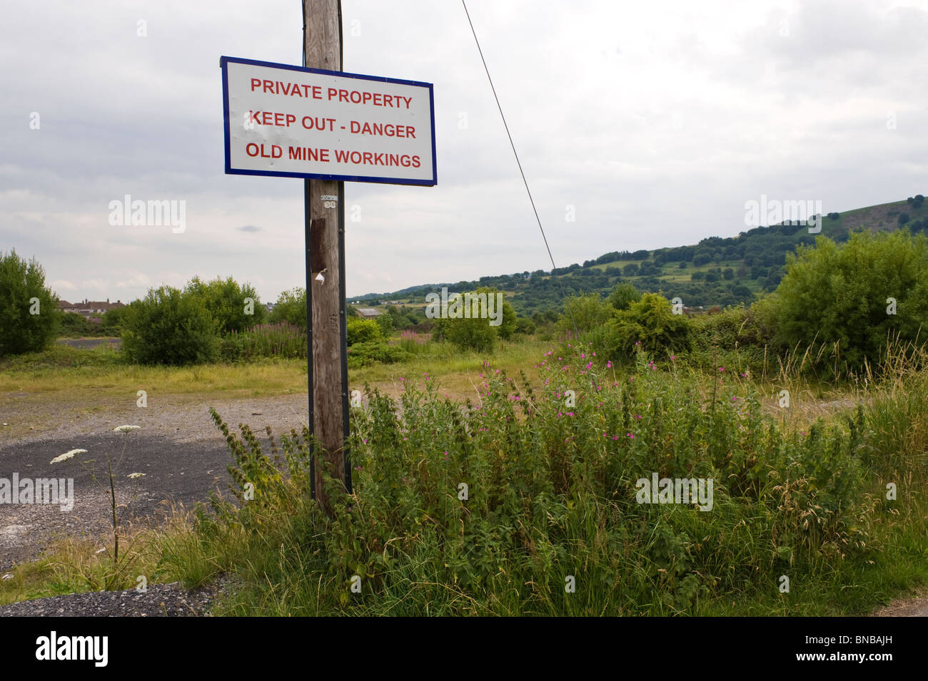 PRIVATE PROPERTY KEEP OUT DANGER OLD MINE WORKINGS sign on former colliery site at The British Torfaen South Wales UK Stock Photo