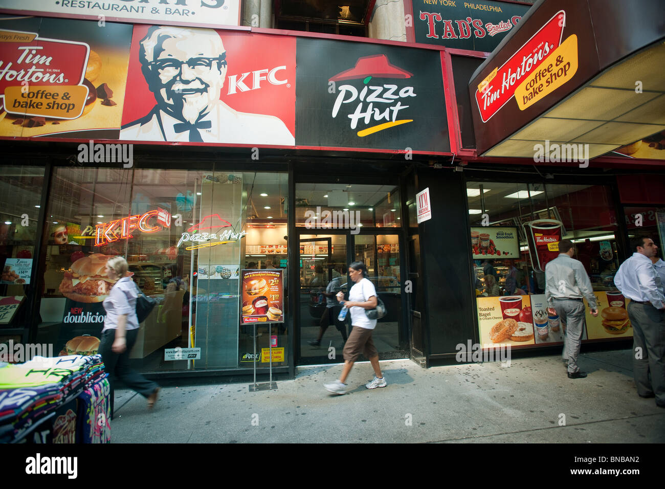 Signs for an assortment of fast food franchises located in one storefront in New York Stock Photo
