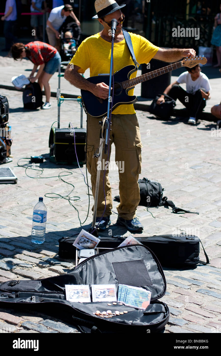 Portrait of a street busker tuning his electric guitar, London, England, UK. Stock Photo