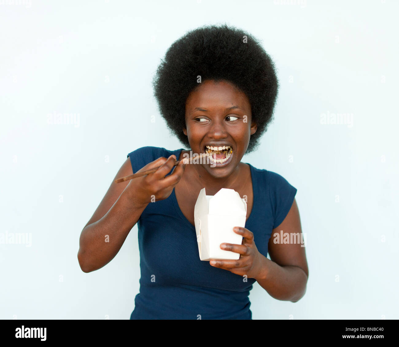 Portrait of woman eating Chinese food with chopsticks Stock Photo