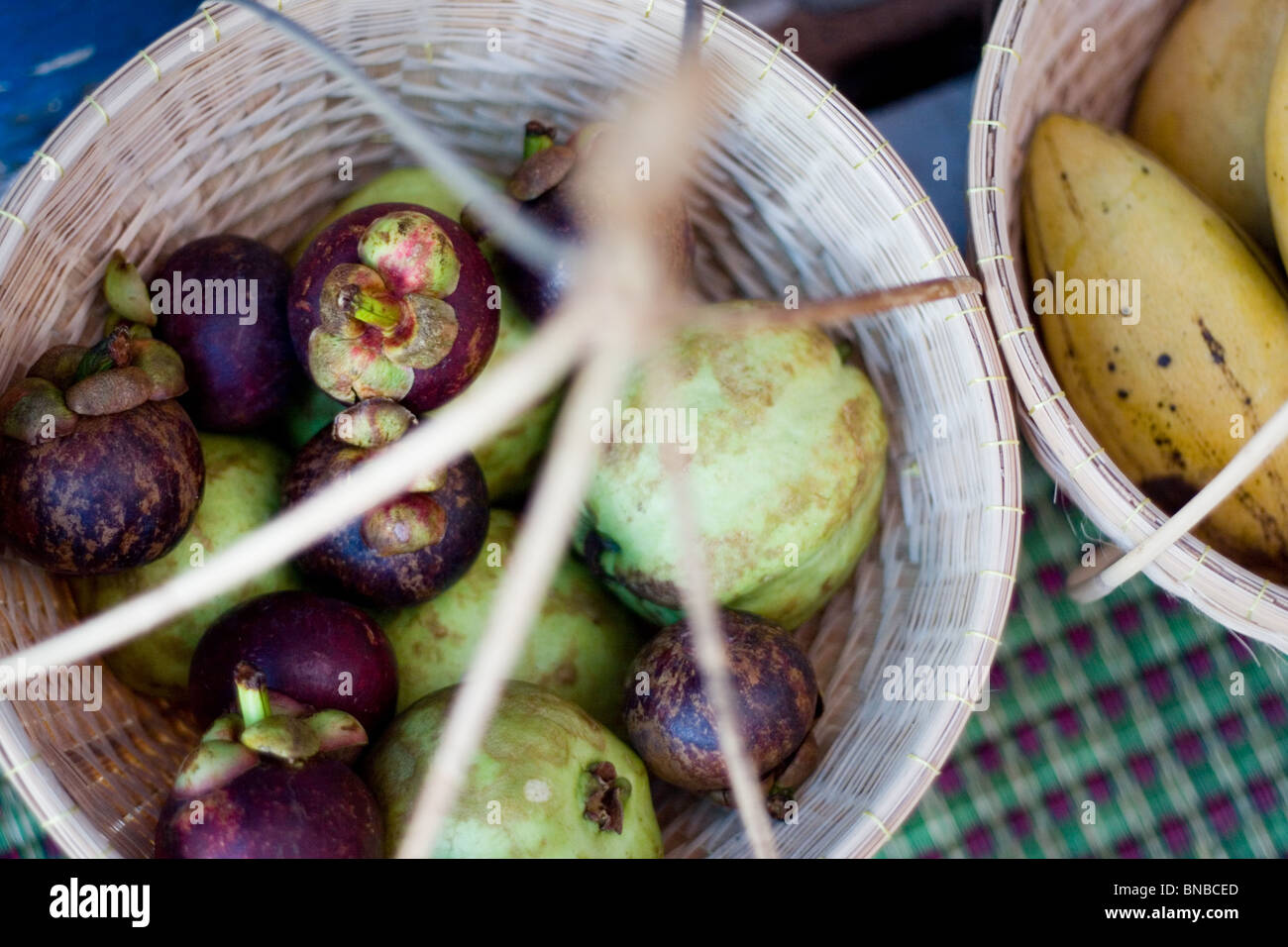 Mangosteens and other tropical fruit in a basket, Thailand Stock Photo