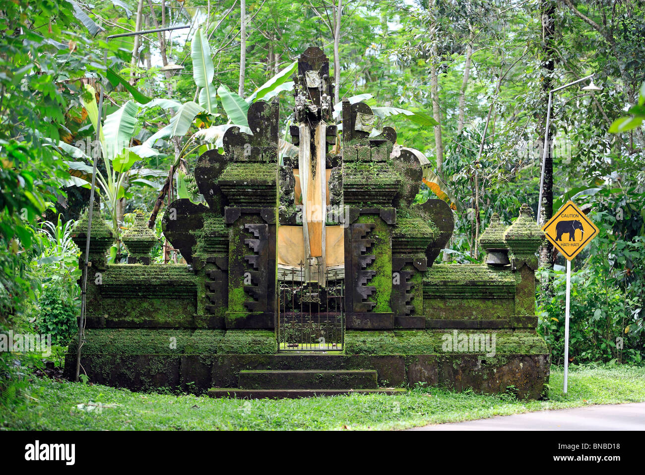 a small temple and shrine near Taro, Ubud, Bali, with a sign next to it warning caution elephants. Stock Photo