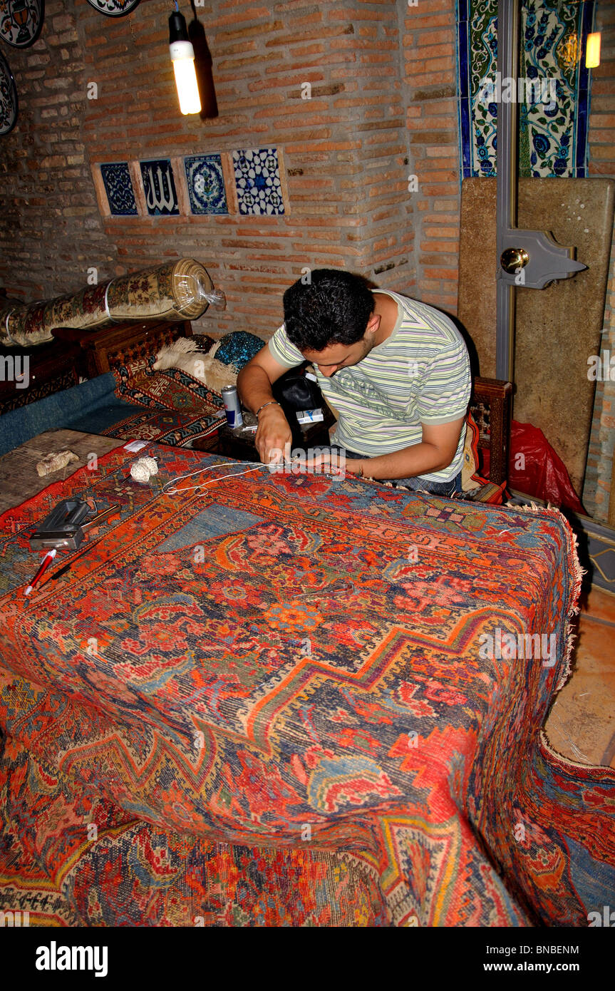 man weaving a Persian carpet in Rome Italy Stock Photo