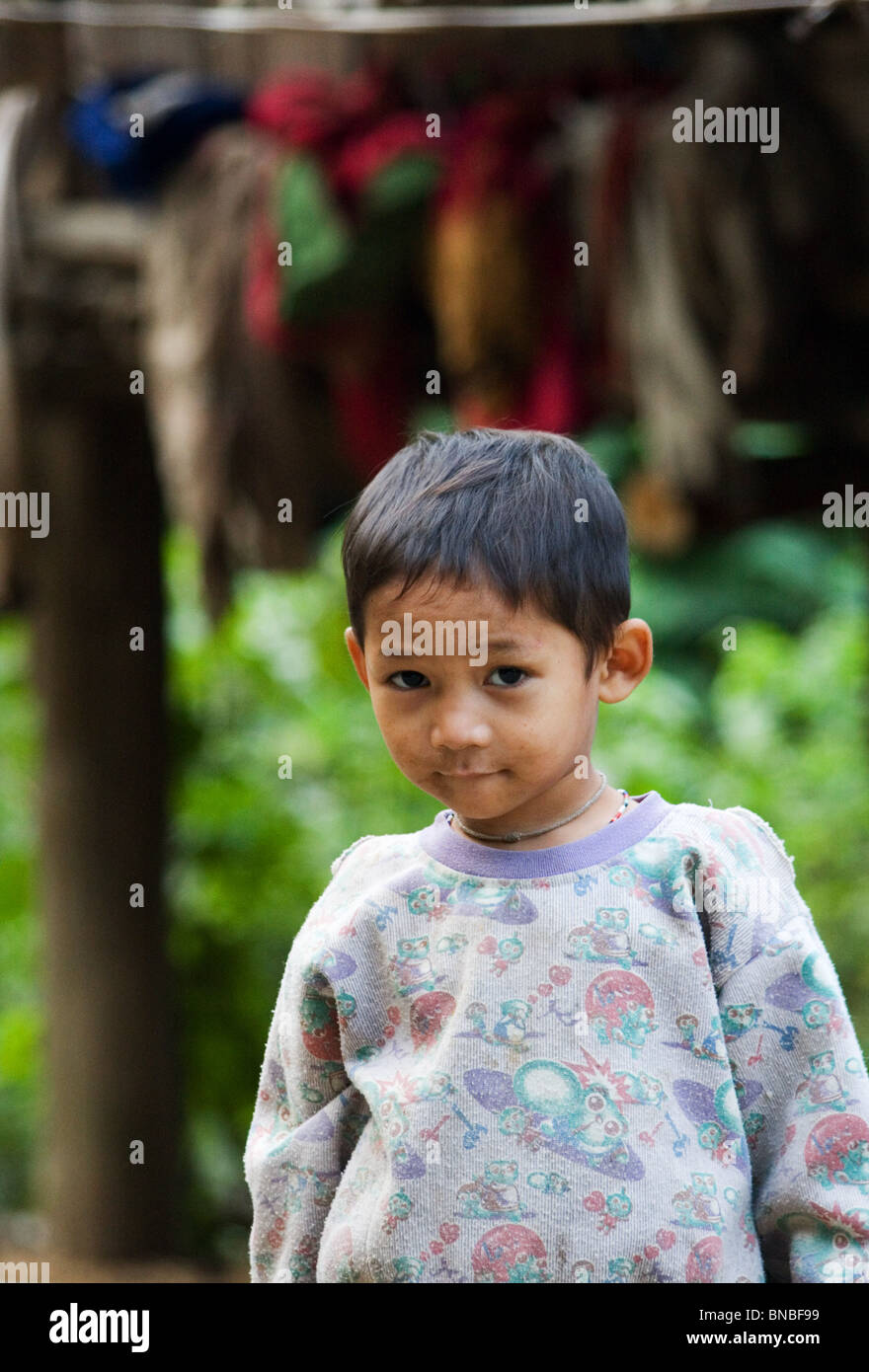 Young boy standing in front of his village home, Mae Sam Laep, Mae Hong Son Province, Thailand Stock Photo