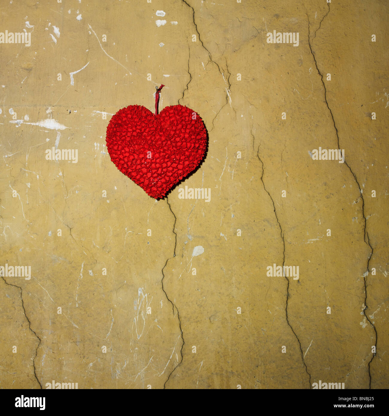 Paper heart fixed on a cracked wall. Stock Photo