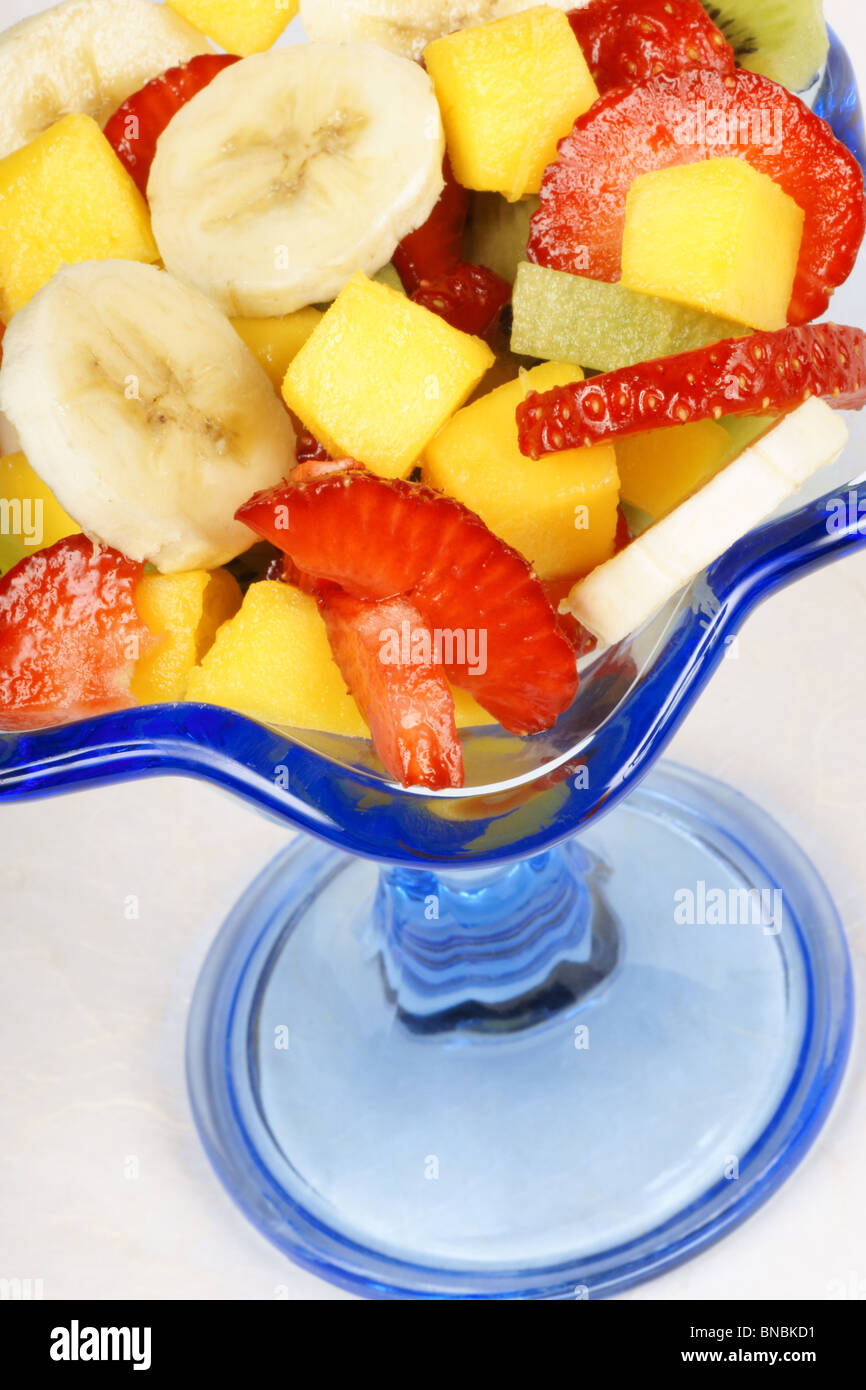 Close-up of a colorful fresh fruit salad in a blue glass cup. Selective focus. Stock Photo