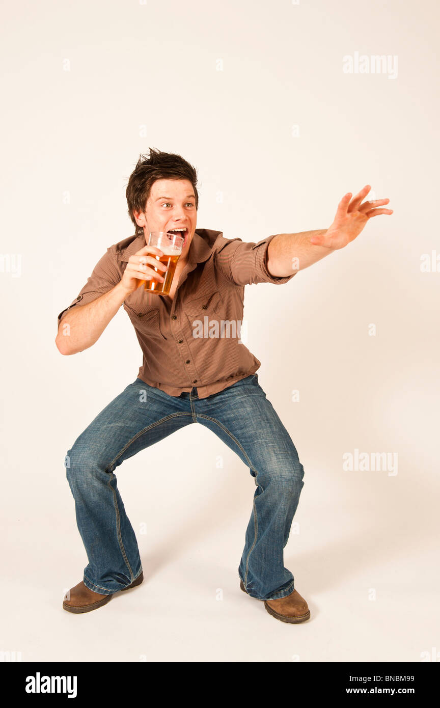 Happy young man drinking a pint of beer lager Stock Photo