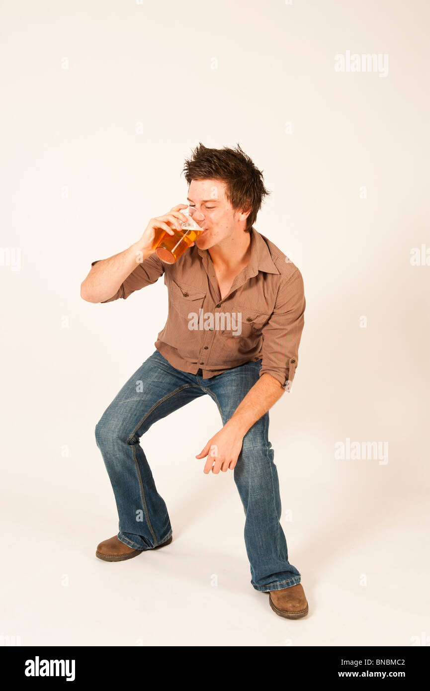 Happy young man drinking a pint of beer lager Stock Photo