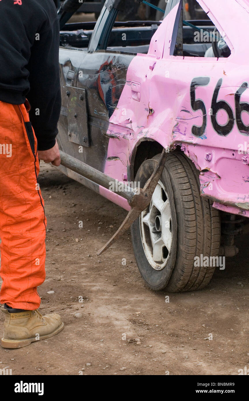 banger racing mechanic driver bending using a pick axe pickaxe scrap junk old car with   hammer repair repairing maintenance cow Stock Photo