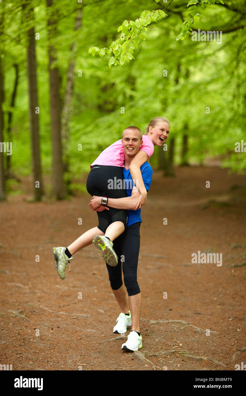 Couple running in forest, having fun Stock Photo