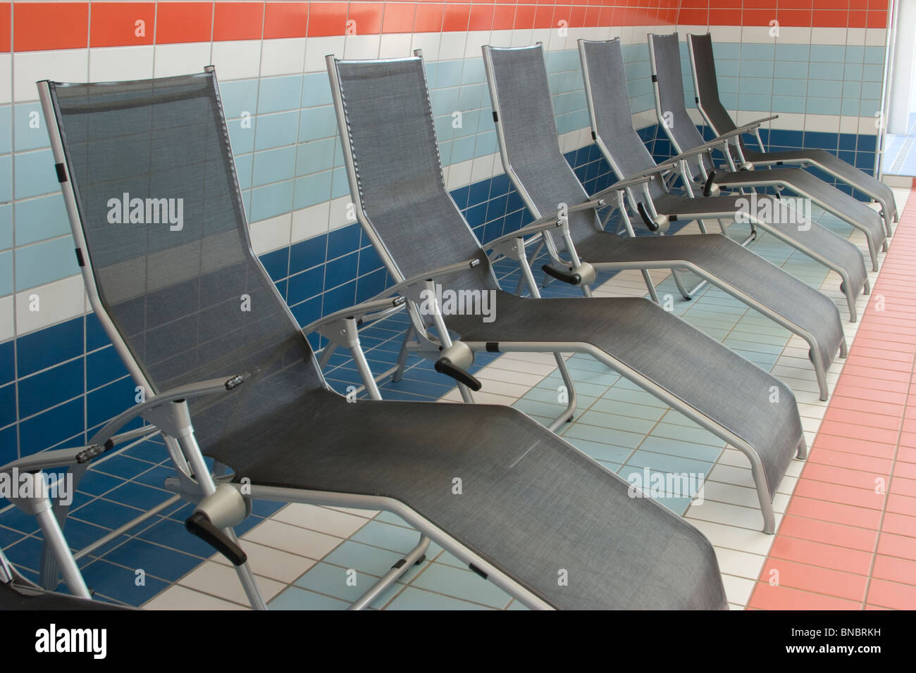 Deckchairs on swimming pool Stock Photo