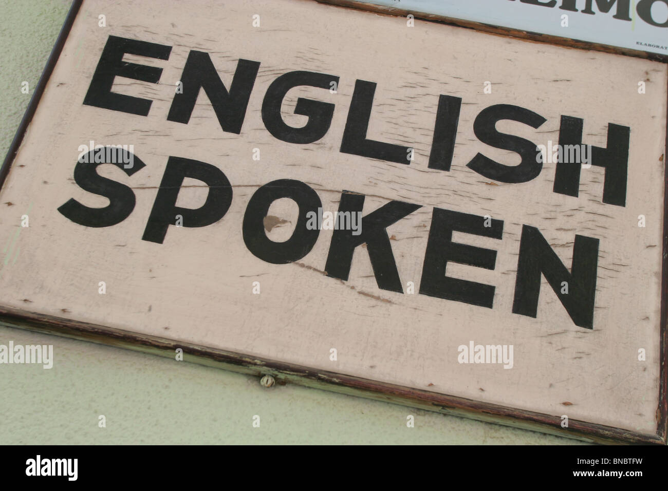 'English Spoken' sign on restaurant wall, Figueres, Catalonia, Spain. Sept2006 Stock Photo