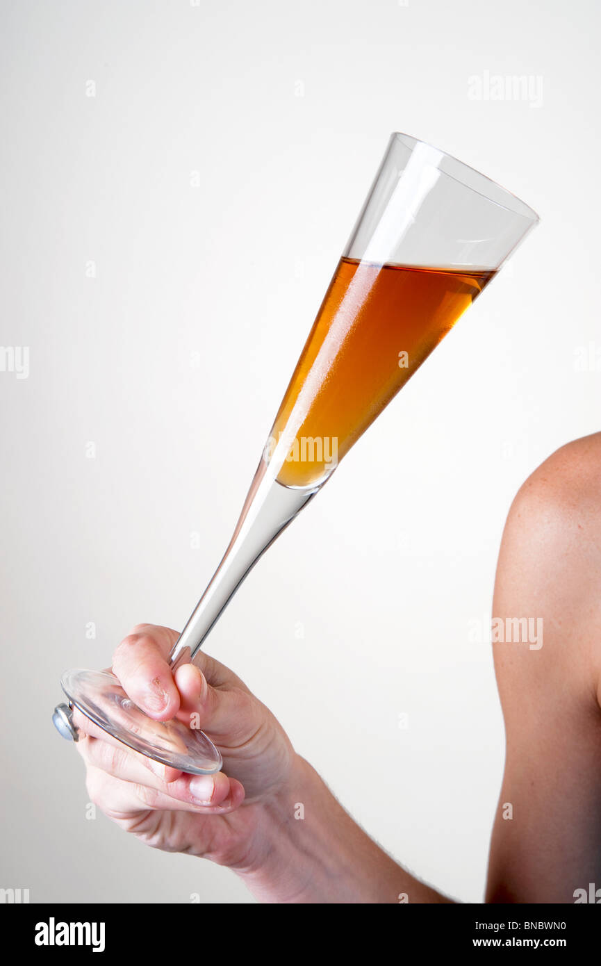 young Woman's shoulder arm and hand holding a cocktail glass at an event Stock Photo