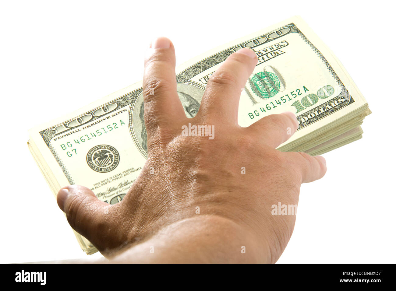 Hand trying to take a stack of dollars Stock Photo