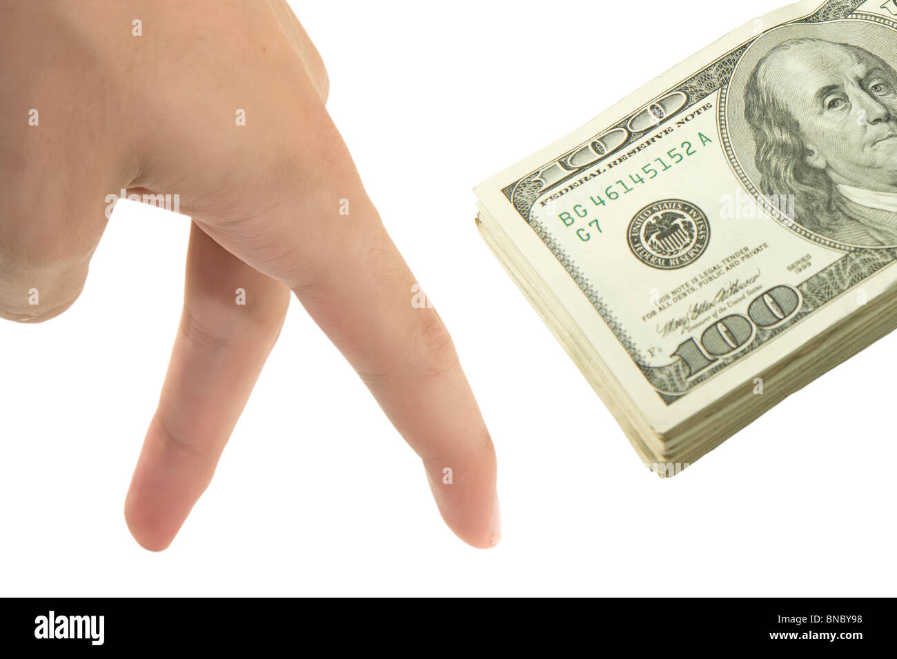 Hand trying to take a stack of dollars Stock Photo