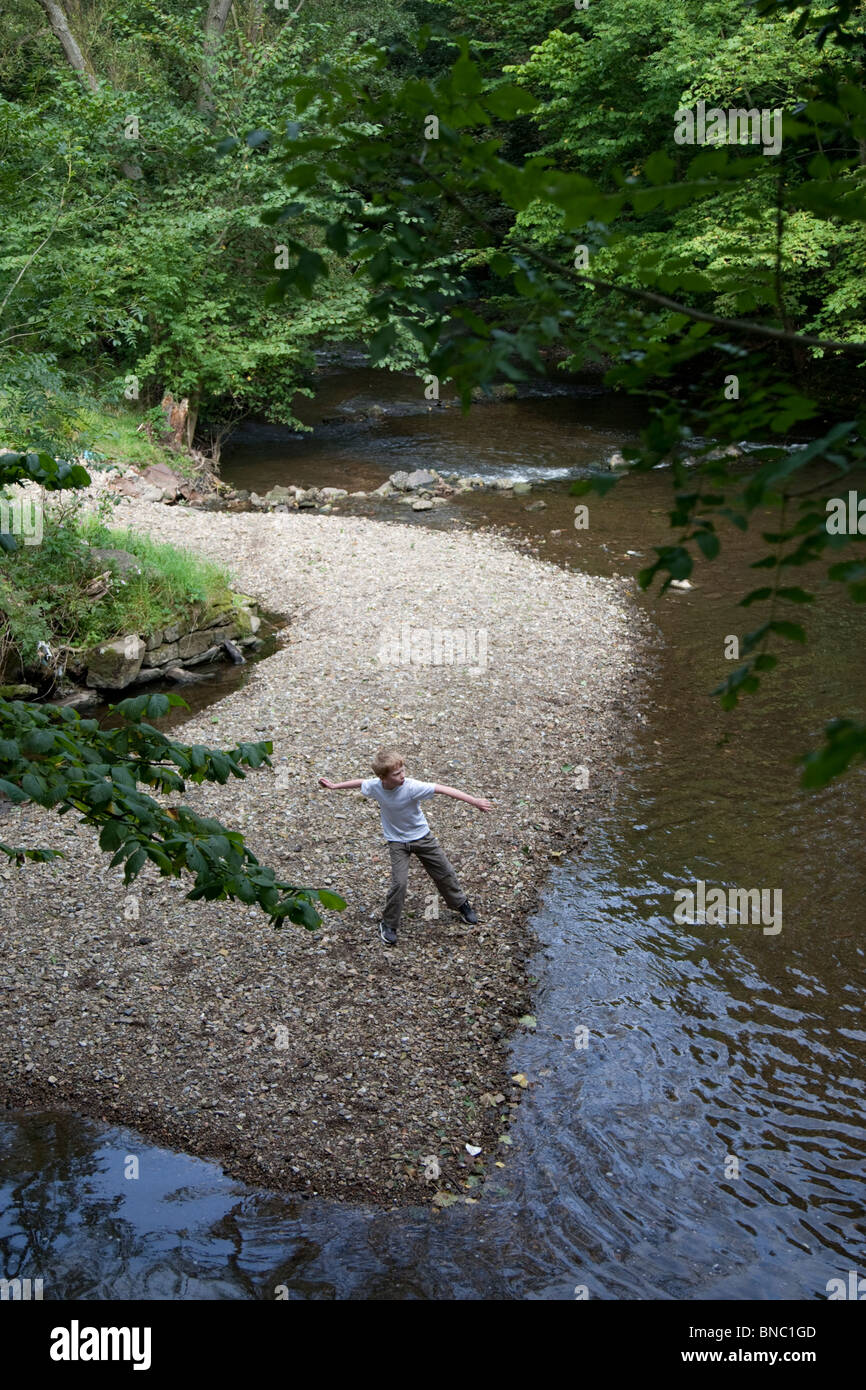 Young boy throwing stones in the River Alyn. Stock Photo