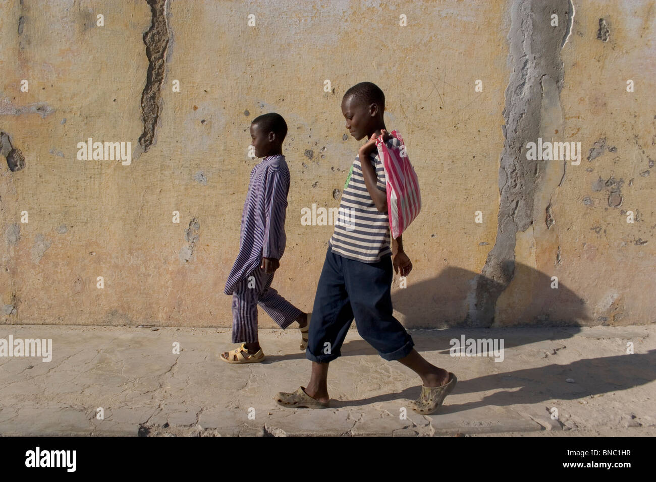 Mozambican boys walking along street, Ilha de Mozambique. Stock Photo