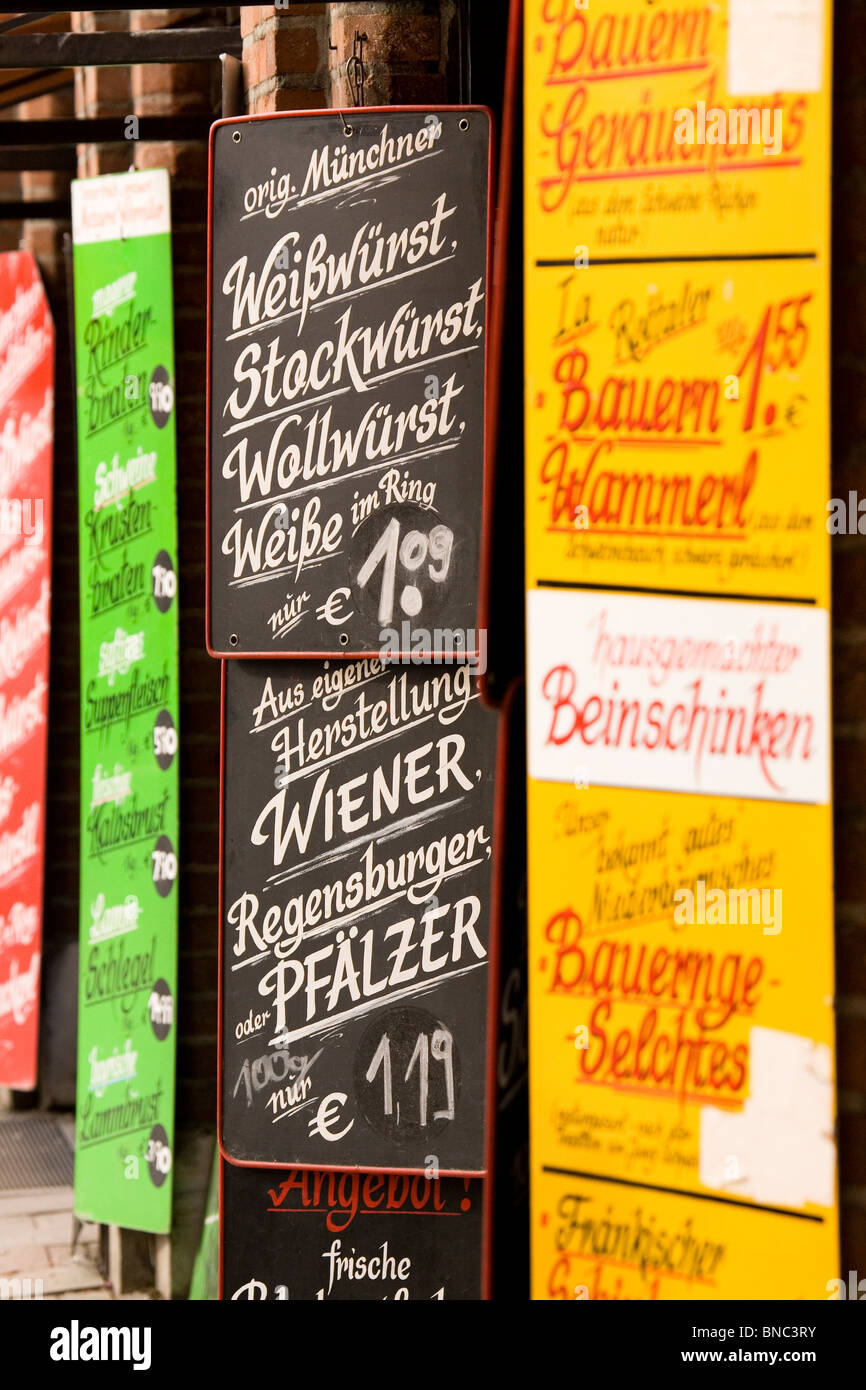 Signs advertise various types of German sausage and meat products at