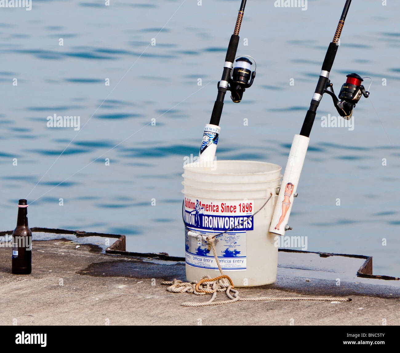 Fishing poles rest in one of the official buckets given to registrants