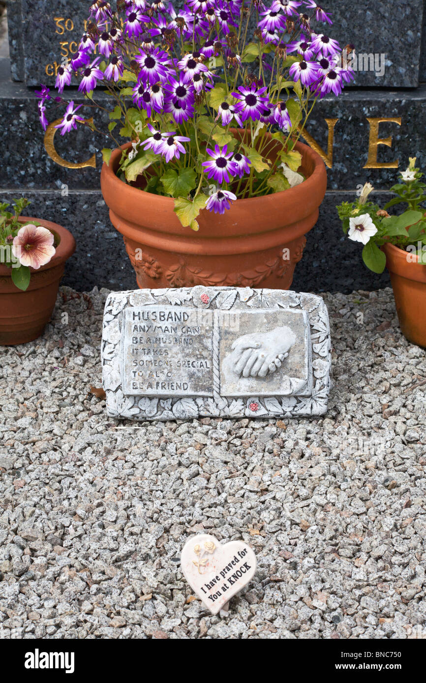 Flowers and plaque with personal message in front of gravestone, Co. Galway, Ireland Stock Photo