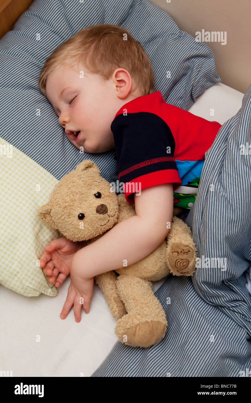 Young boy asleep in his bed, cuddling his teddy bear Stock Photo - Alamy