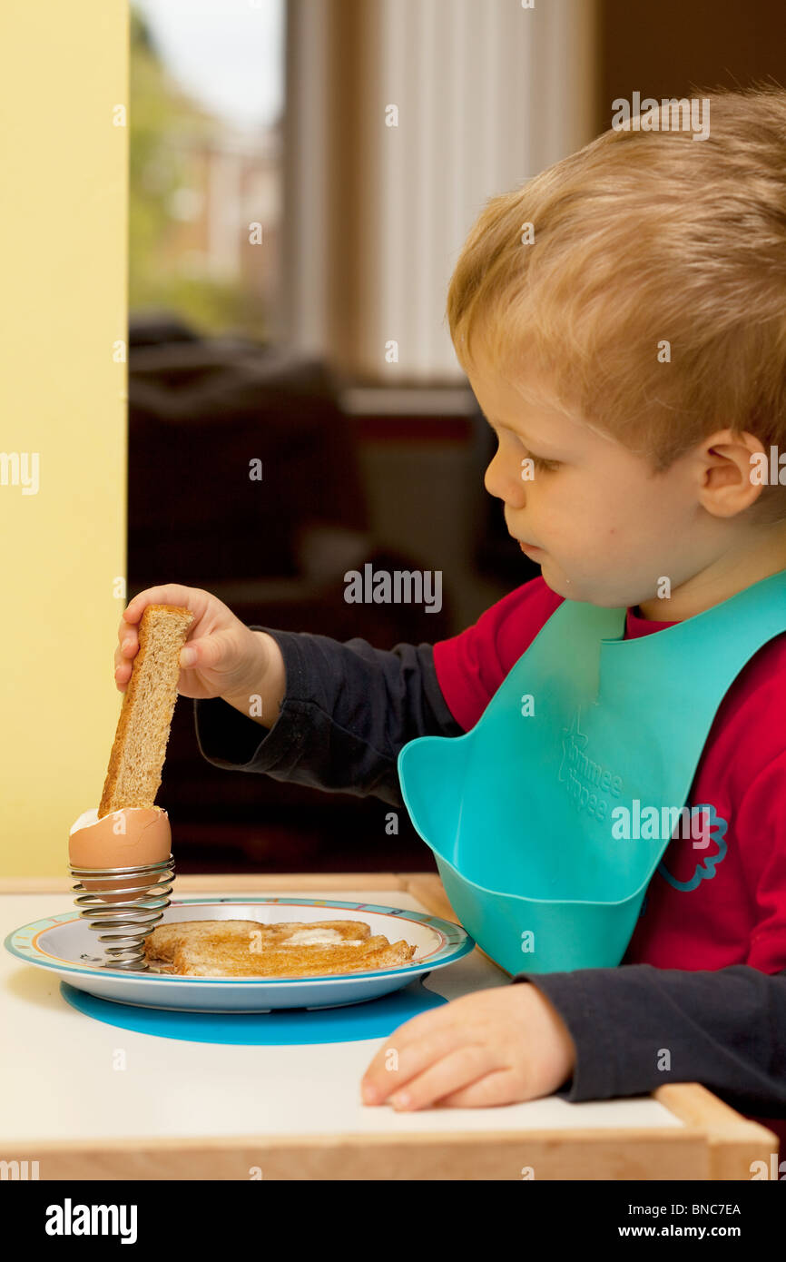 Young boy eating a soft boiled egg for breakfast Stock Photo Alamy