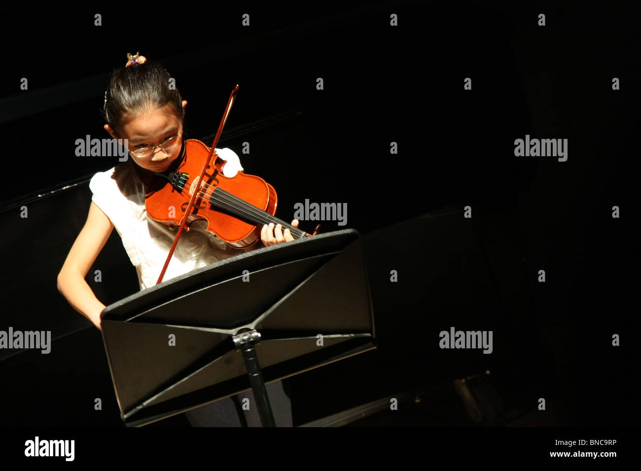 Young Asian girl play violin musical performance Stock Photo