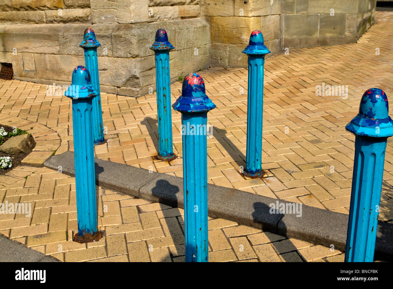 Peeling paint on vehicle barrier posts at a railway station Stock Photo