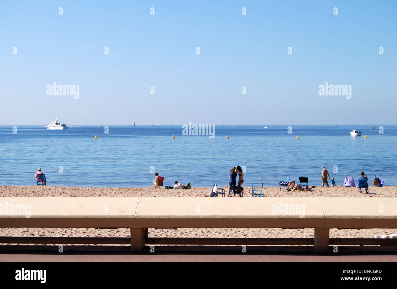 Sandy beach with people on shoreline along La Croisette at Cannes. Cote d'Azur. France Stock Photo
