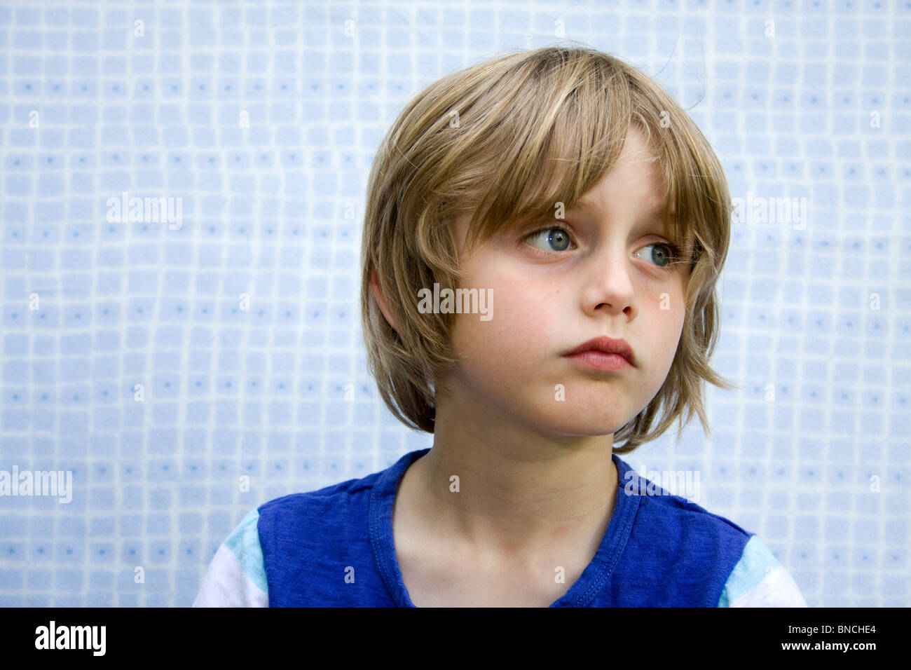 young boy against blue background Stock Photo - Alamy
