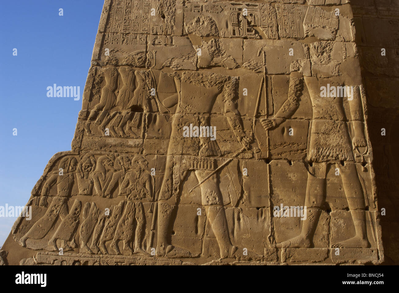 Relief depicting prisoners of war at the feet of Pharaoh Ramses III who presents them victorious before god Amun. Egypt. Stock Photo