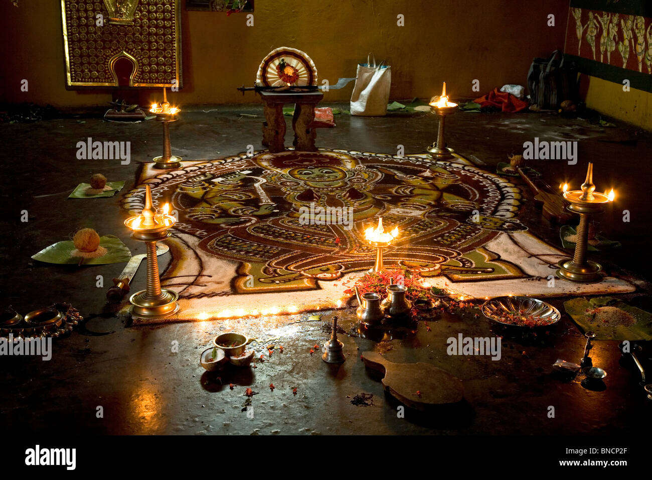 Silver vessels stand ready for a puja (ritual prayer) next to a Kalam ...