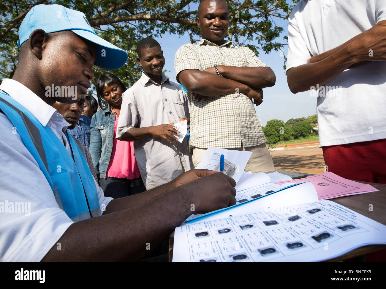 A worker from the Ghana Electoral Commission checks the identity of a voter during elections in Accra, Ghana Stock Photo