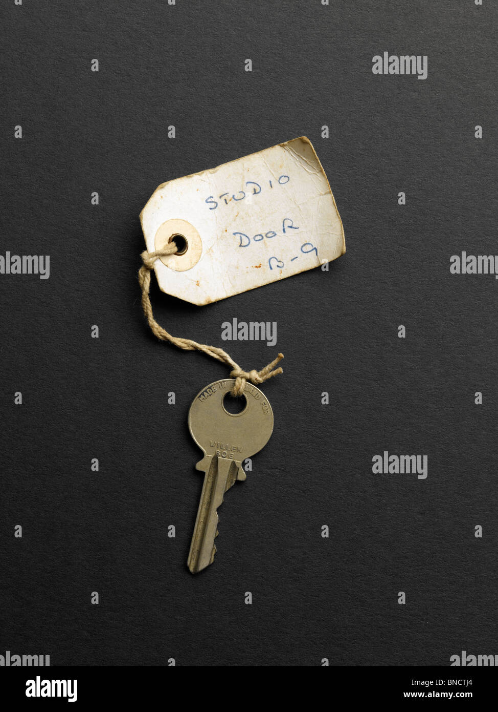 Old key with label with the witing 'Studio Door B-9' Stock Photo