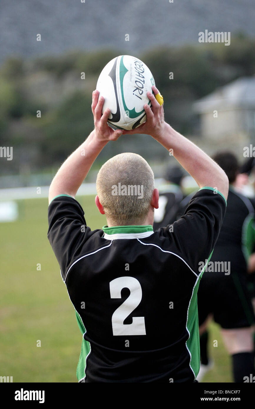 A player throws in the ball during a 'line out' at a rugby match. Stock Photo